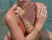 Woman with gold jewelry by a pool