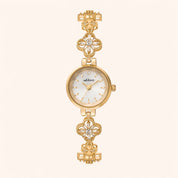 Gold watch with decorative band on a white background